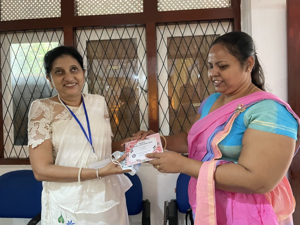 Handing over a Braille calendar to a vision-impaired person