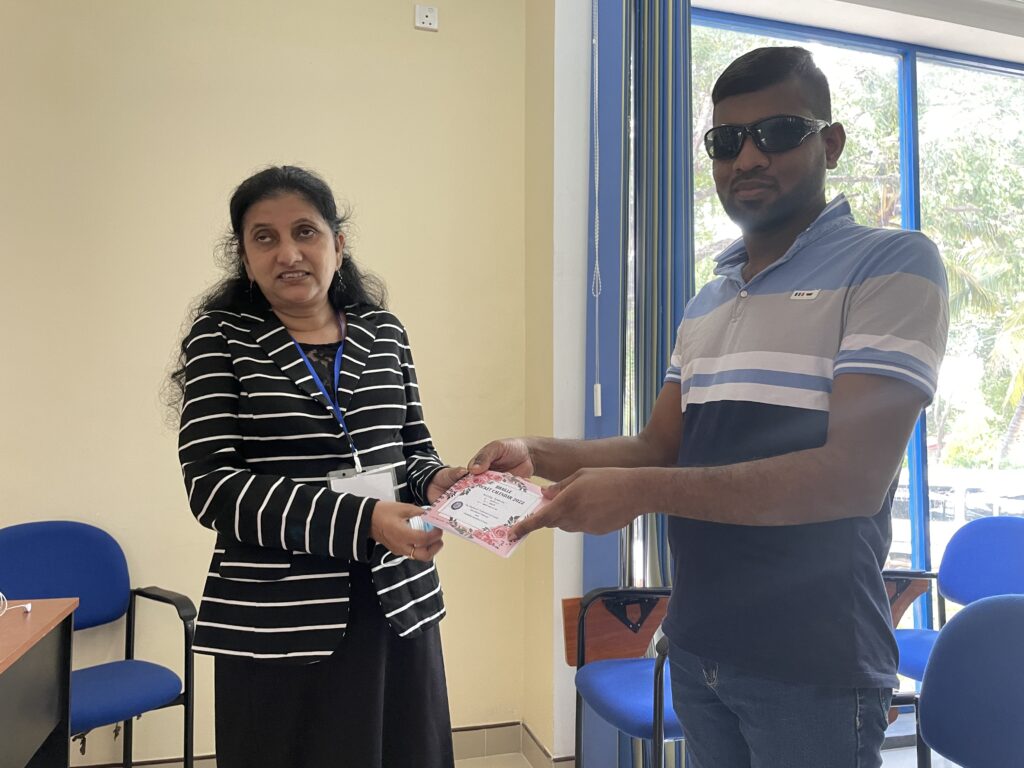 Handing over a Braille calendar to a vision-impaired person