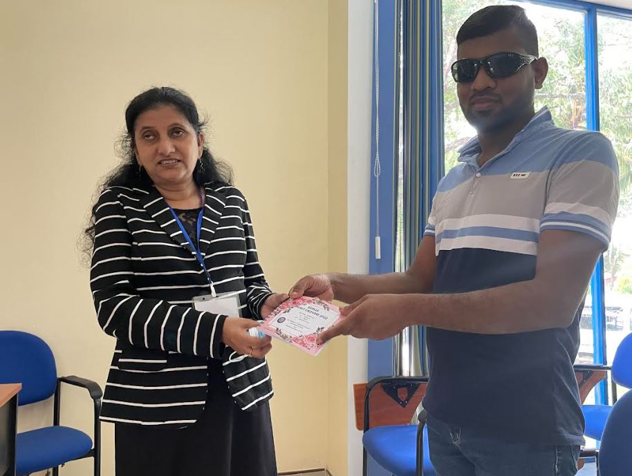 Handing over a Braille calendar to a vision impaired person